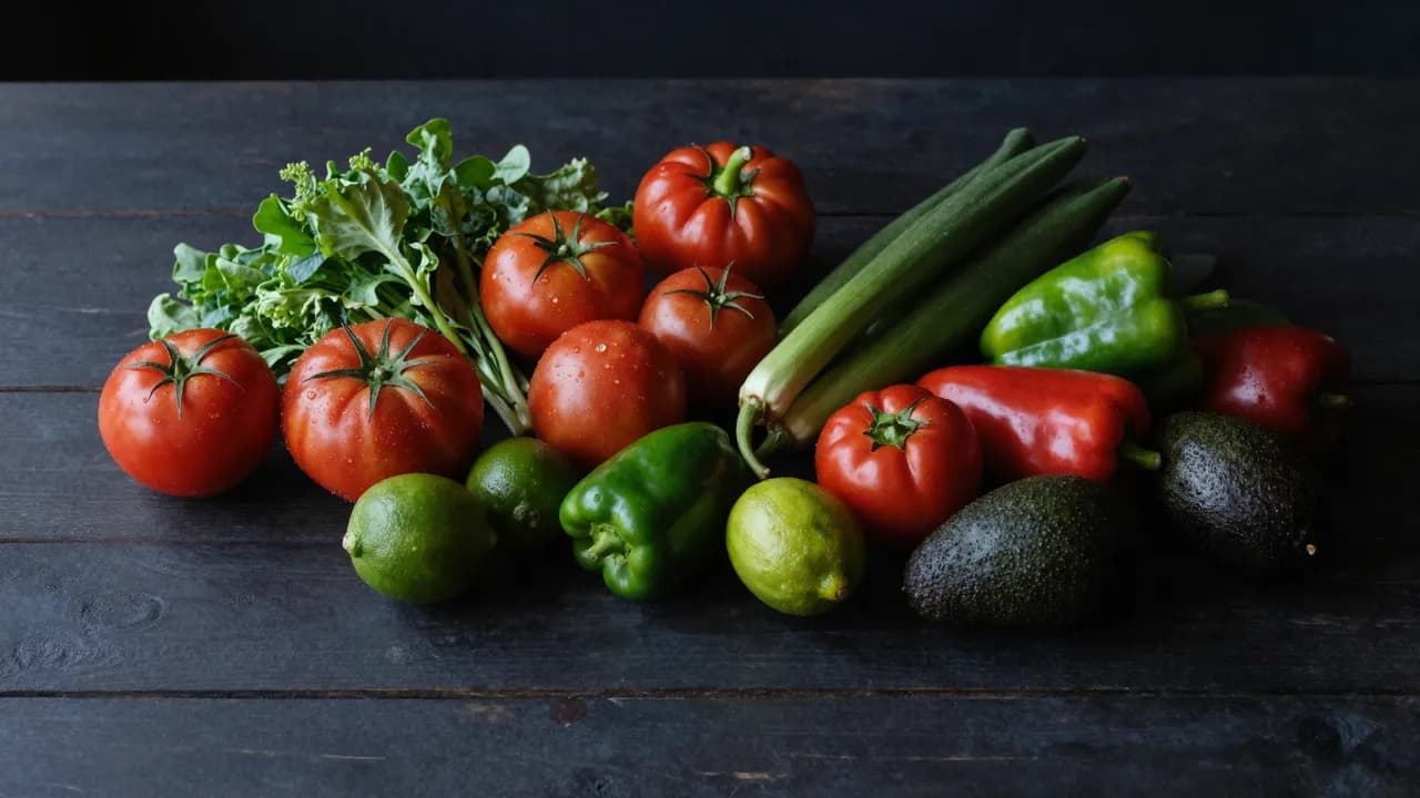 Vegetales y frutas frescas sobre mesa de madera oscura
